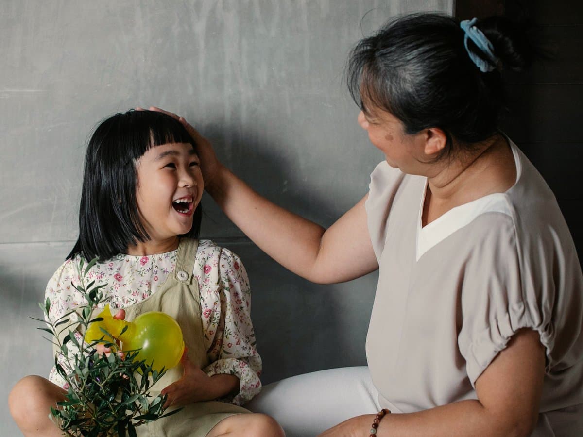 A domestic helper sharing a joyful moment with a child at home in Singapore